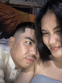 a man and a woman are posing for a picture and the man has a mustache