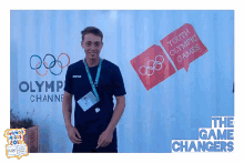 a young man stands in front of a sign that says youth olympic games