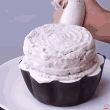 a person is frosting a cake that looks like a cup