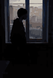 a silhouette of a person sitting in front of a window with a yellow light behind them