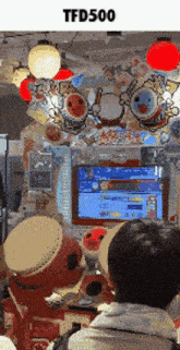 a man is playing a video game with a tfd500 logo above him