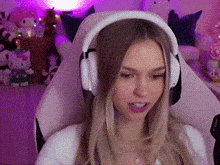 a woman is wearing headphones while sitting in a gaming chair .