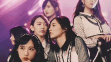 a group of women are standing in a row looking at the camera