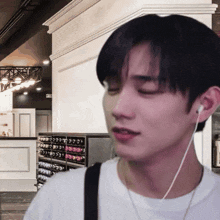 a young man wearing ear buds looks at something