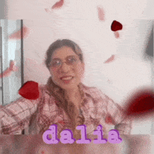 a woman wearing glasses and a plaid shirt is surrounded by hearts and the name dalia