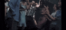 a group of people are dancing in a club in a blurry photo .