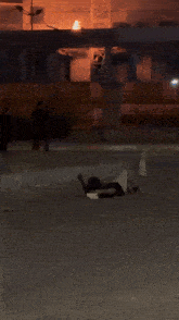 a person laying on the ground in front of a building