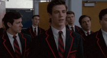 a group of men in suits and ties are standing in a line