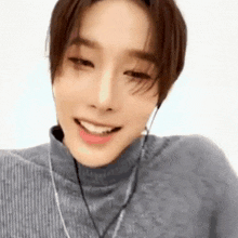 a close up of a person wearing a turtleneck sweater and headphones .