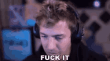 a man wearing headphones is saying `` fuck it '' in front of a computer screen .