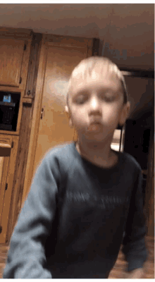 a young boy wearing a sweater that says ' tommy hilfiger ' on the front