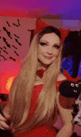 a woman wearing devil horns and a red dress
