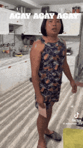 a man in a dress is standing in a kitchen with the caption " acay acay acay "
