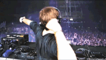 a man wearing headphones stands in front of a crowd with his arms outstretched and the words thissoundworld on the bottom