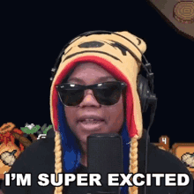 a woman wearing a tiger hat and sunglasses is standing in front of a microphone .