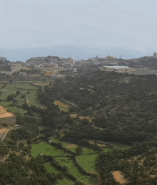 a city is visible in the distance behind a valley