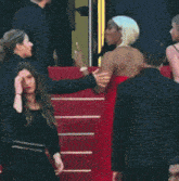 a woman in a red dress is being held by a man in a black suit