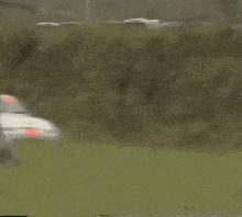 a white race car with a red stripe on the front is driving down a road