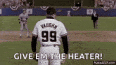 a baseball player wearing a number 99 jersey is standing on a field .