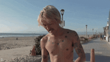 a man without a shirt has a tattoo on his chest that says " i 'm tired "
