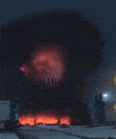 a giant robot is surrounded by flames in a dark room