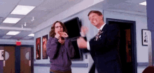 a man and a woman are dancing in a hallway in a hospital .