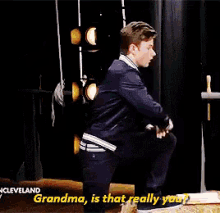 a woman in a yellow jacket is holding a piece of paper and says grandma is that really you