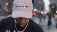 a man wearing a pink hat that says new york city on it