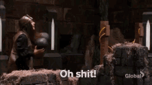 a man in a helmet is standing in front of a wooden torture device and saying `` oh shit ! ''