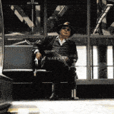 a man wearing a hat and sunglasses is sitting in a chair with the word marvin written on the bottom