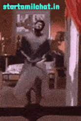 a man is dancing in front of a mirror with the website starttamilchat.in written above him