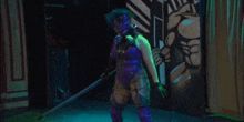 a woman in a purple costume is holding a stick