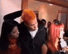 a man with red hair is standing next to a woman with red hair and a microphone .