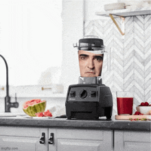 a vitamix blender with a man 's face on it sits on a kitchen counter