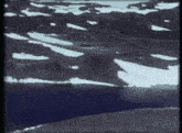 a lake surrounded by snowy mountains and a few trees