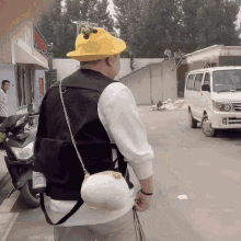 a man wearing a yellow hat and a black vest