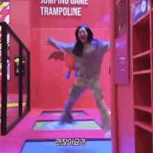 a woman is jumping on a trampoline with a sign that says jumping game trampoline
