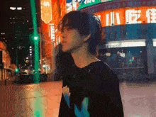 a man in a black shirt stands in front of a sign that says ' a ' on it