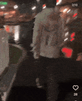a blurry picture of a person walking down a street with the number 28 on the bottom
