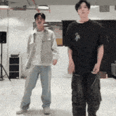 two men are standing next to each other in a room and dancing together .
