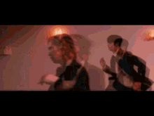 a group of men in suits are dancing together in a room .