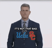 a man in a suit and tie with the ucla logo on his jacket