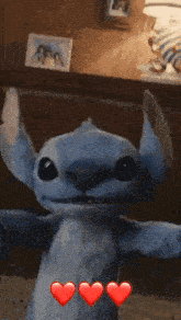 a stuffed animal with three red hearts on it 's chest