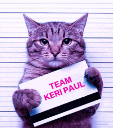 a cat is holding up a sign that says team keri paul