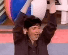 a person with their arms in the air with the letter h visible