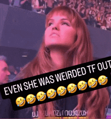 a woman in a stadium with a banner that says even she was weirded tf out