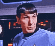 a close up of a man 's face with a star trek logo on his shirt