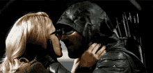 a man in a hooded jacket is kissing a woman in a leather jacket