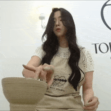 a woman wearing an apron that says yotoro ceramic studio on it