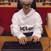 a person wearing a white polo ralph lauren sweatshirt is typing on a keyboard